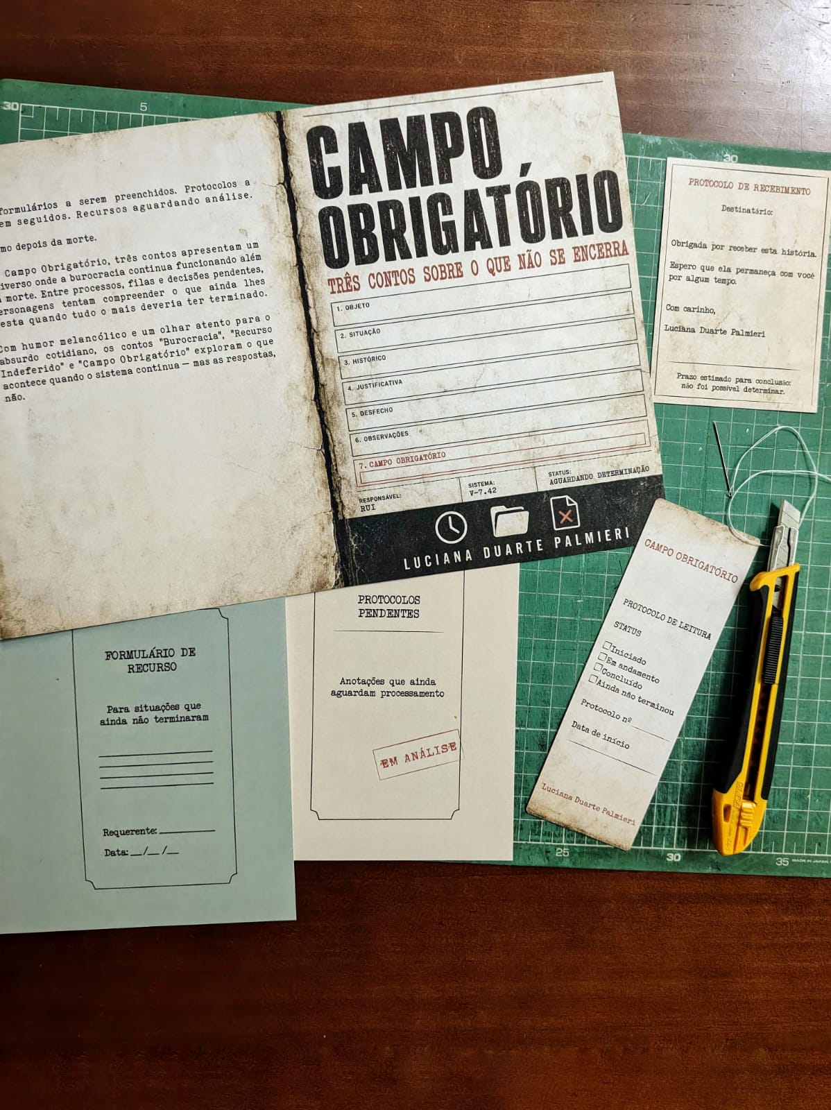 Edição artesanal de Campo Obrigatório costurada à mão, acompanhada de cartão de protocolo, marcador e etiqueta de exemplar numerado 07 de 10